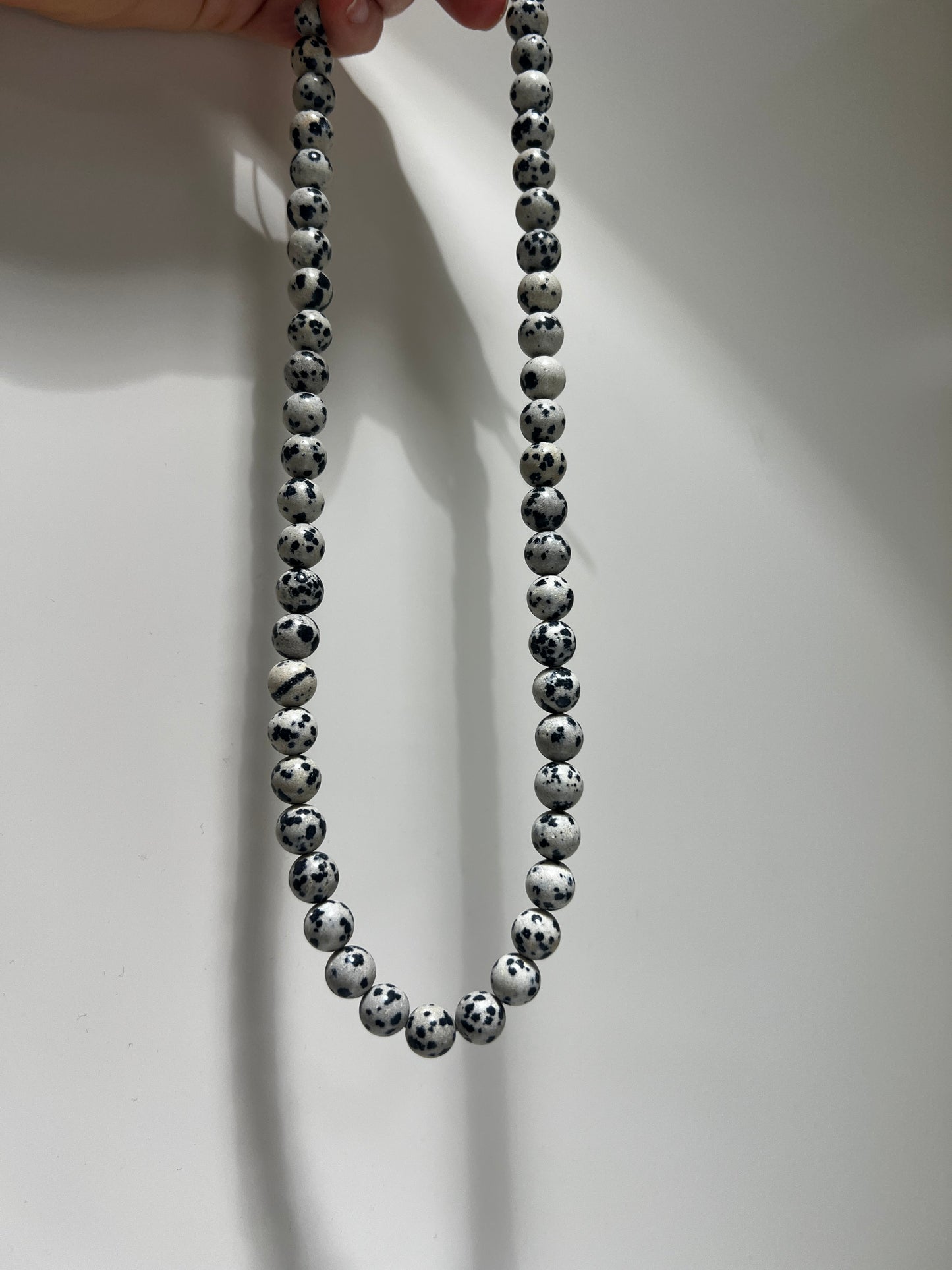 Silver beaded necklace on a white background