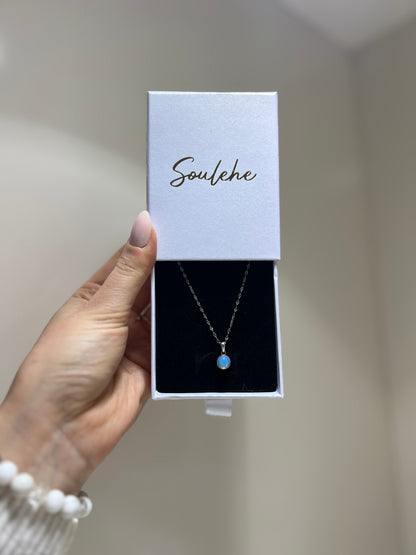 Necklace in a 'Soulehe' box held by a hand against a neutral background
