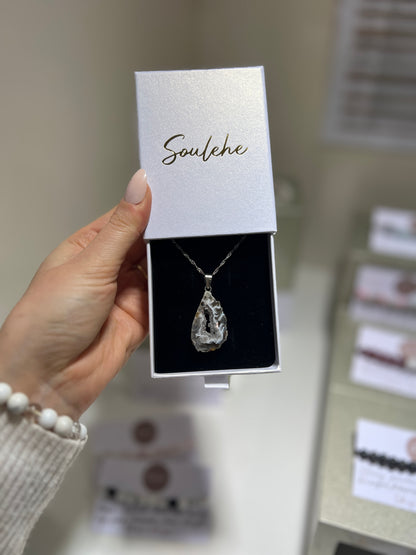 Necklace in a 'Soulehe' box held by a hand with blurred background