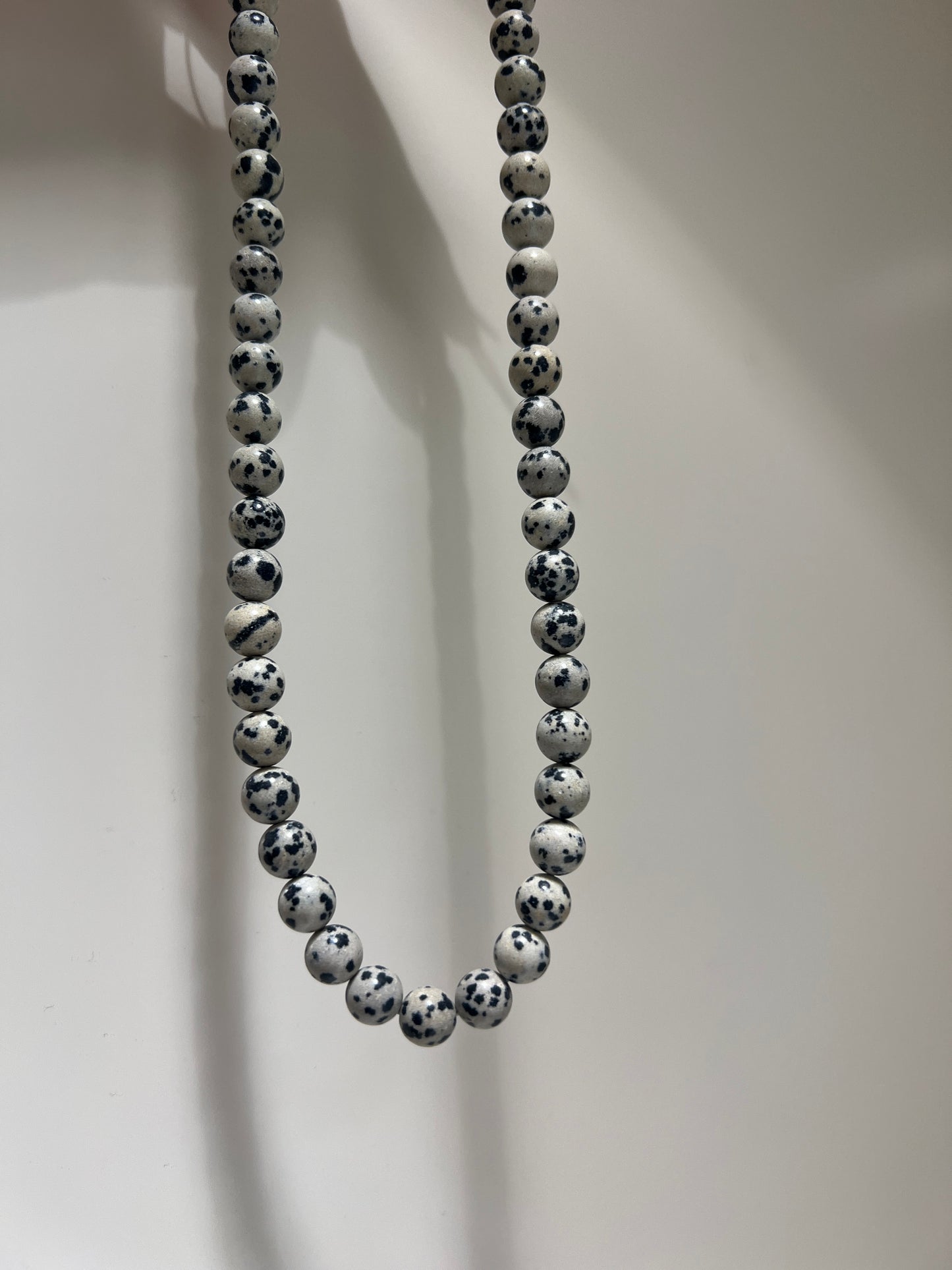 Beaded bracelet with black and white pattern on a light background