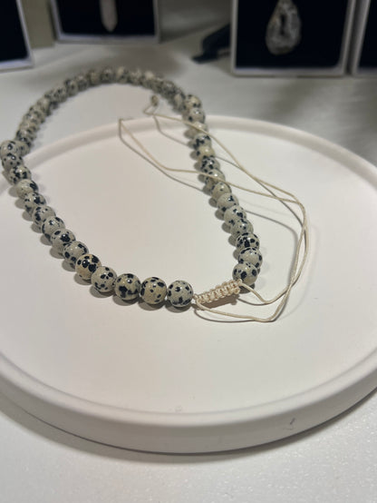 Necklace with dalmatian Jasper beads on a white surface