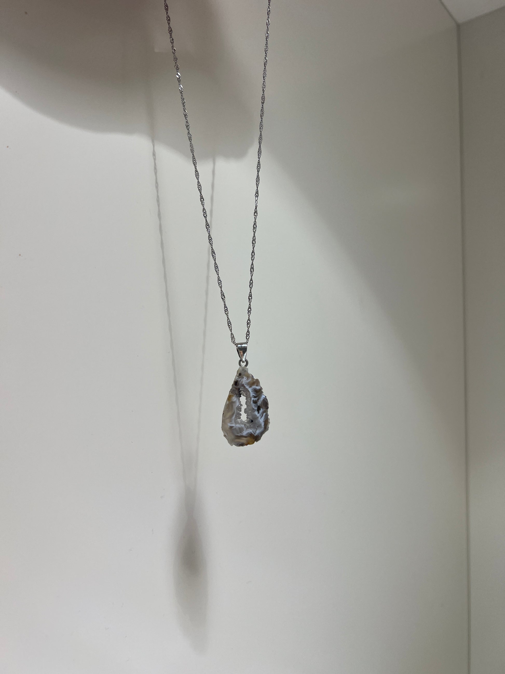 Silver necklace with a pendant on a white background