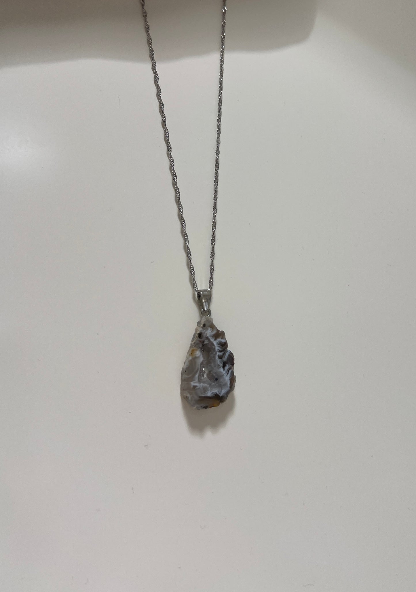 Silver necklace with a pendant on a white background