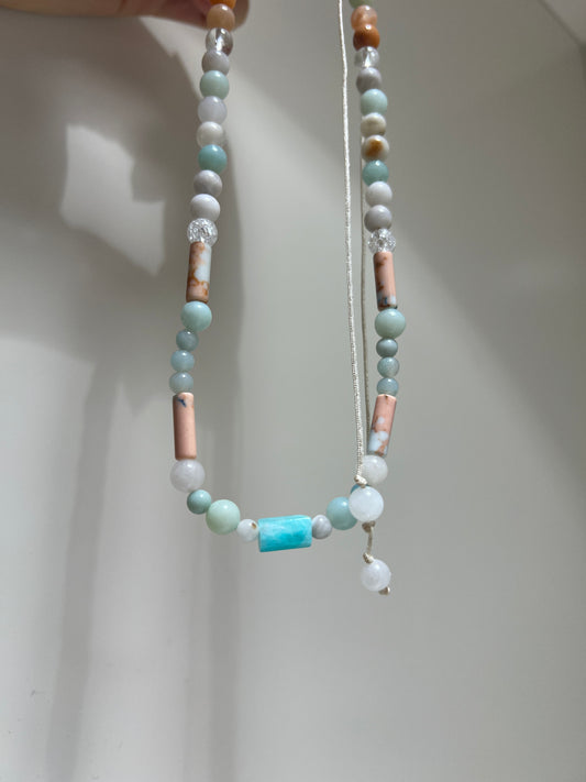 Beaded necklace with multicolored beads on a plain background